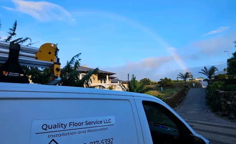 A white Quality Floor Service LLC van is parked on a road with a rainbow in the sky and palm trees in the background.